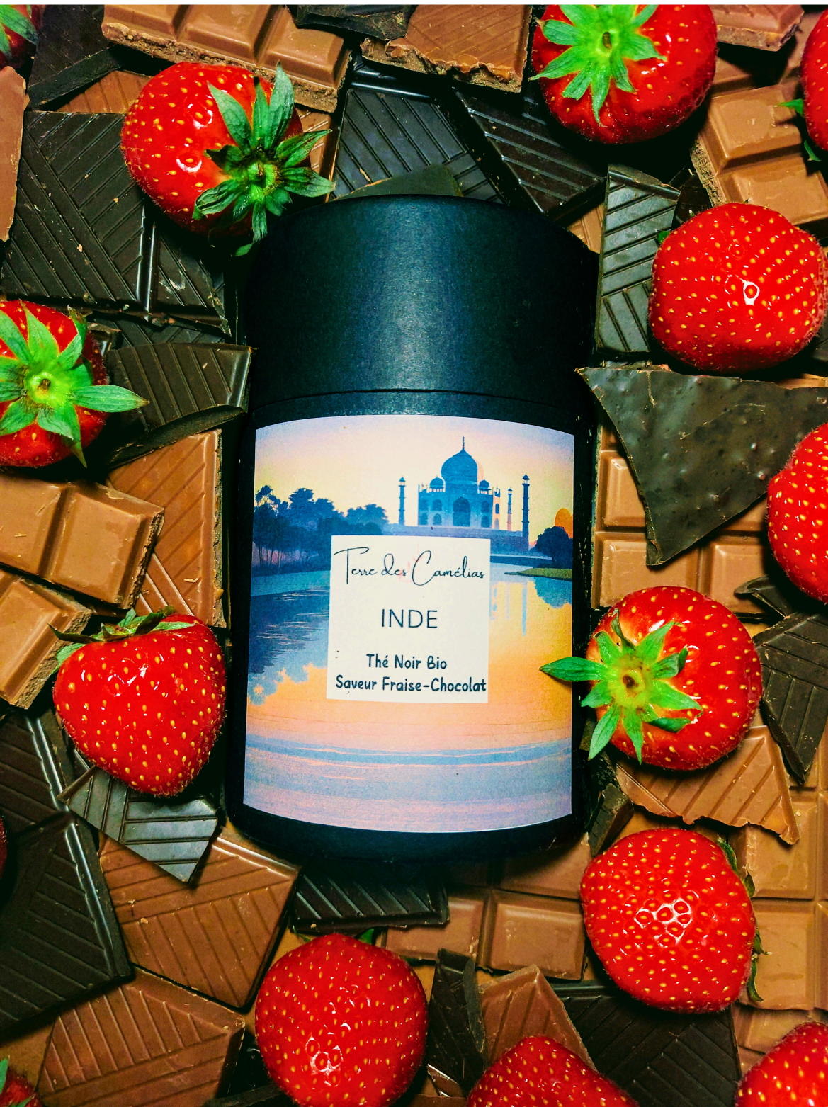 Boîte de thé noir d'Inde au milieu de fraises et de chocolat