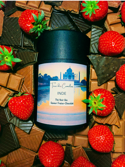 Boîte de thé noir d'Inde au milieu de fraises et de chocolat